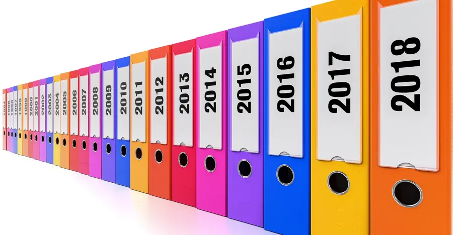 Colour-coded binders labelled by year running back in a row