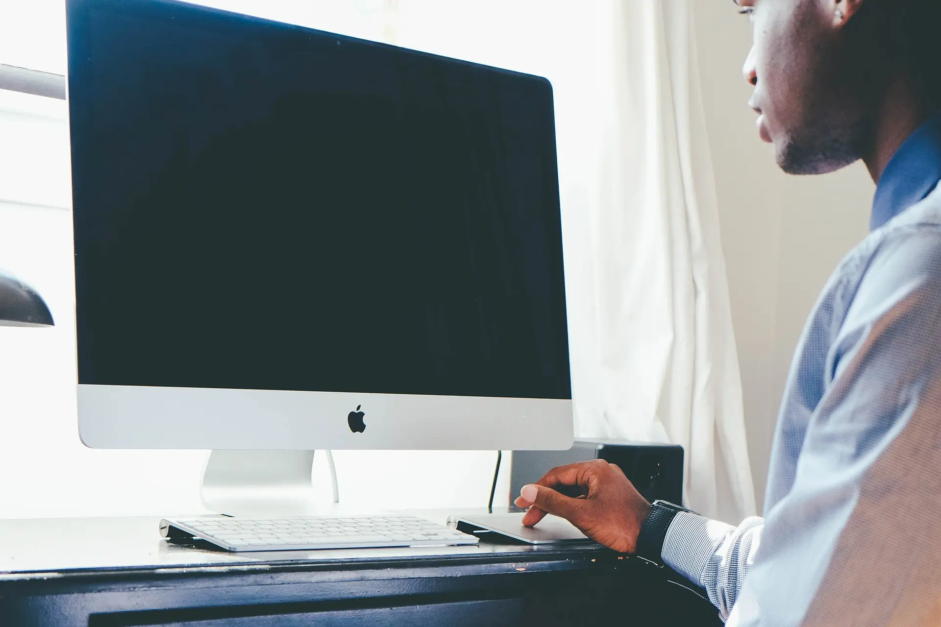 Bookkeeper working at a desktop computer in a bright office
