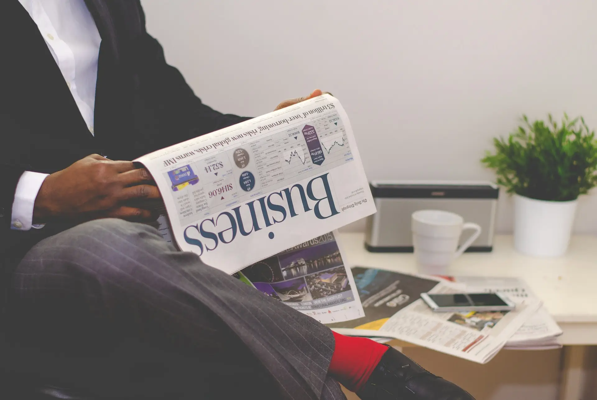 Business owner reading the business pages at his desk