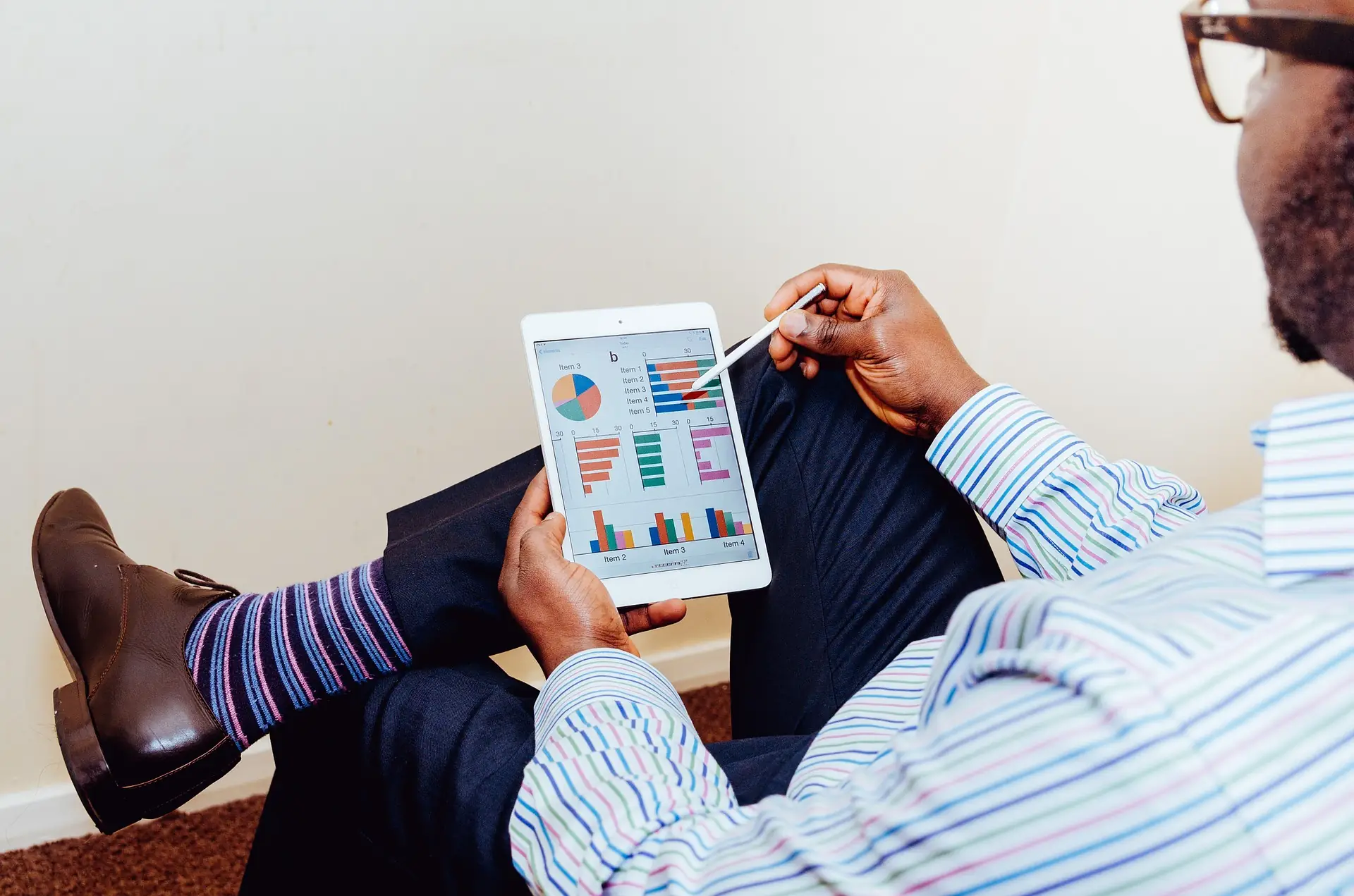 Business owner reviewing charts on a tablet with his feet up